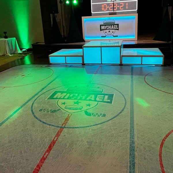An ice rink with a scoreboard and green light, creating a lively atmosphere similar to a dance floor in Dallas, TX