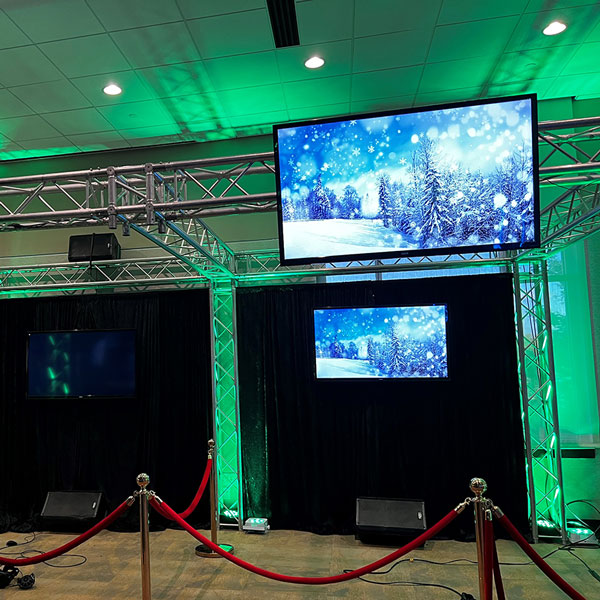 A room in Dallas, TX, illuminated with green lights and featuring large LCD/LED monitors on display